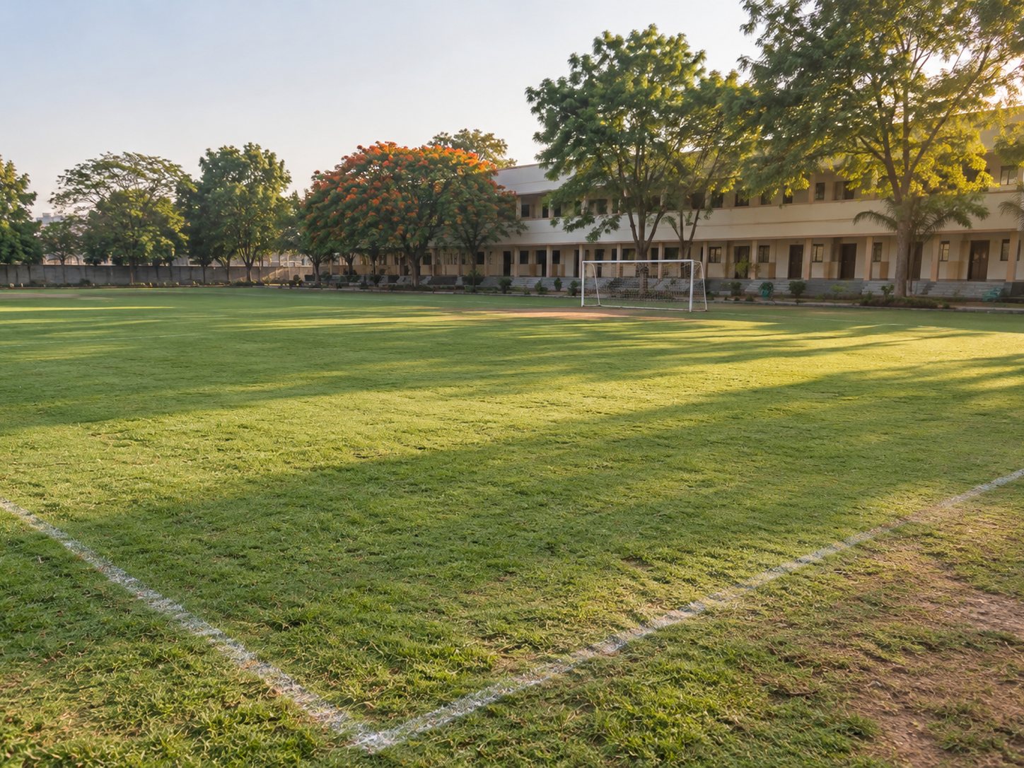 Gardener mowing and edging a campus lawn.